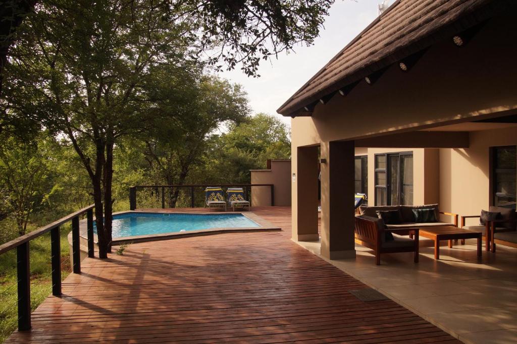 um deque com piscina e uma casa em Uchawi wa Afrika em Marloth Park