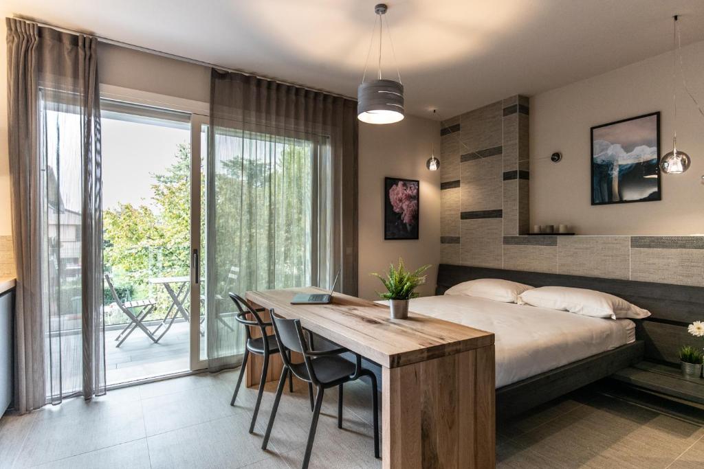 佩斯基耶拉德爾加爾達的住宿－SEI Garda Apartments，一间卧室配有一张床和一张桌子及椅子