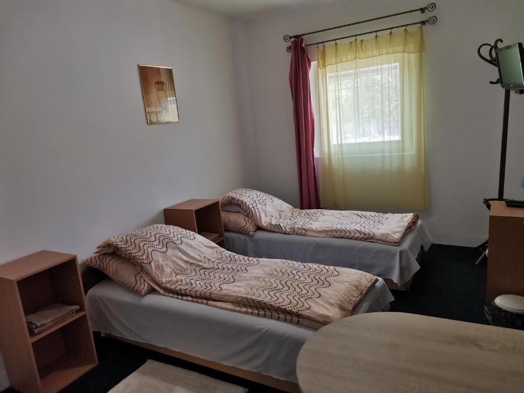 Habitación con 2 camas y ventana en Vendégház Kalocsa, en Kalocsa