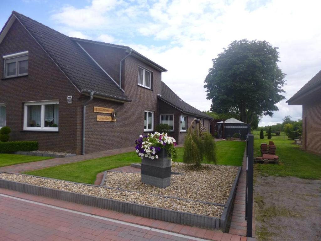 una casa con una caja de flores en el patio delantero en Ferienwohnung- Haus Anna, en Papenburg