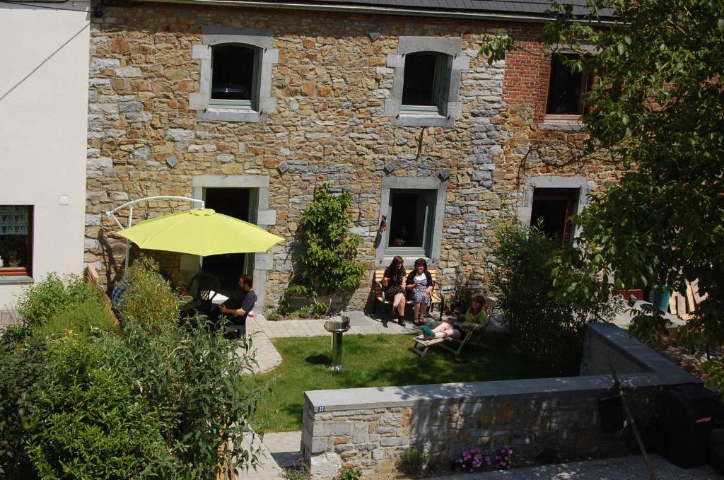 um grupo de pessoas sentadas em frente a um edifício em Le Clos des Haies, Silenrieux em Cerfontaine