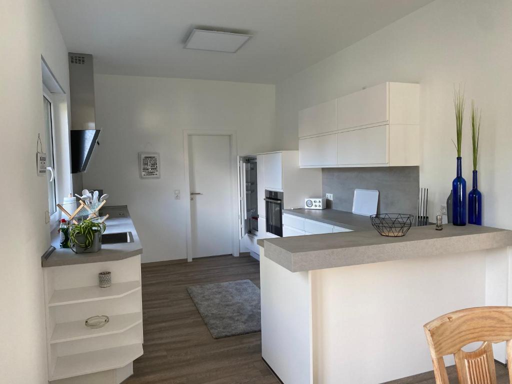uma cozinha com armários brancos e uma bancada em Ferienwohnung Jette em Westerstede