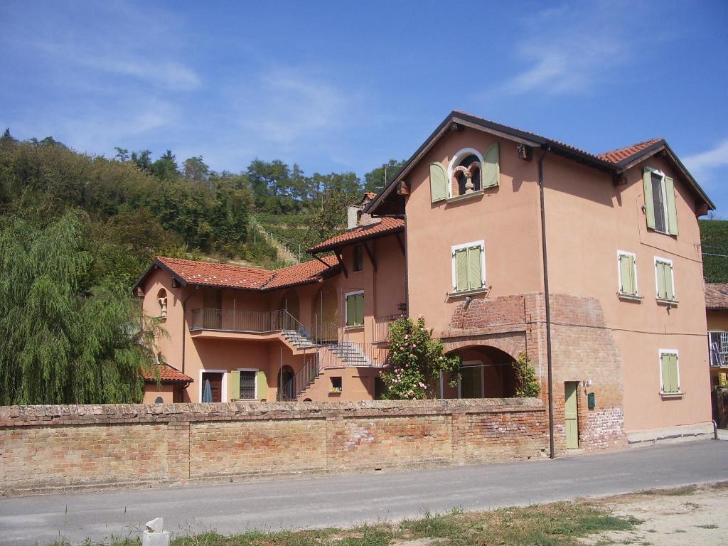a large brick house with a window and a wall at Guest House I Vicini di Cesare in Castelnuovo