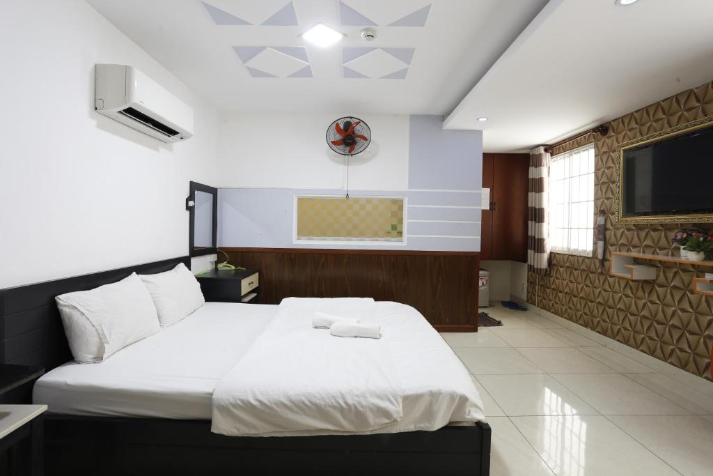 - une chambre avec un grand lit et une télévision dans l'établissement OYO 1149 Avatar Hotel, à Hô-Chi-Minh-Ville
