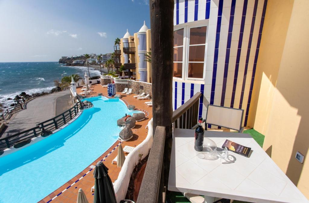 een balkon met uitzicht op een zwembad en de oceaan bij Altamar 44 balcony&pool By CanariasGetaway in Playa del Aguila