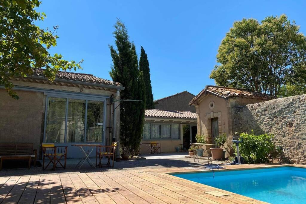 una casa con piscina y patio en Cave atelier dans ancien domaine viticole, en Moux