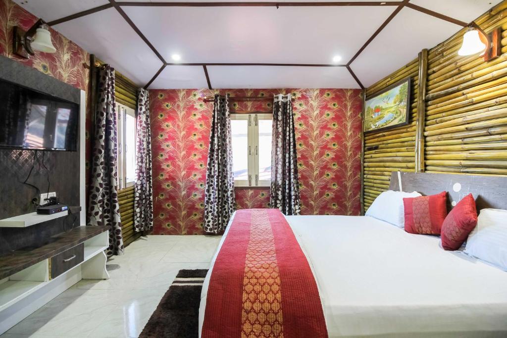 a bedroom with a large bed and a television at Glamwood Resort Dhanaulti, Ranked 1 in Dhanaulti in Dhanaulti