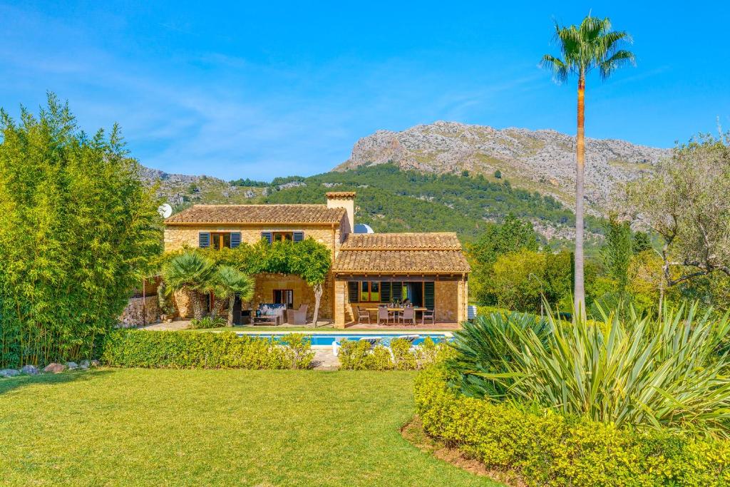 een huis met een zwembad en een palmboom bij Can Peric in Pollença