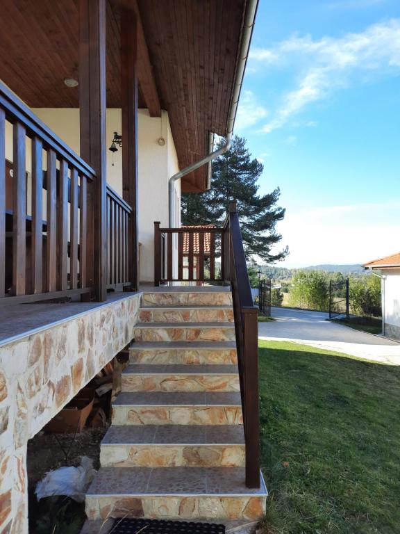 a set of stairs leading to a porch of a house at Вила Мариам Villa Mariam in Batak