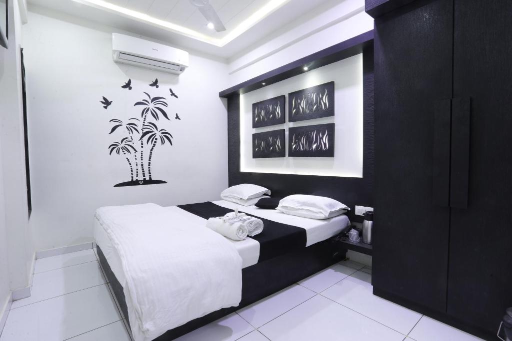 two beds in a room with black and white at Hotel Paramount Inn in Rajkot