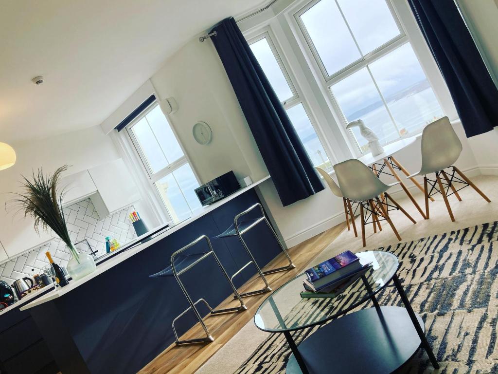 a living room with chairs and a counter and windows at Seascape Scarborough Stunning Seaview Holiday Home Apartment in Scarborough