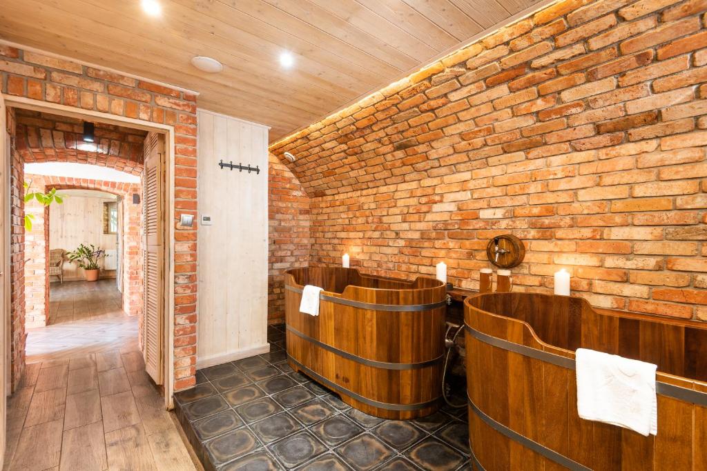 a room with a brick wall and wooden barrels at Pałac Spichrz in Borcz