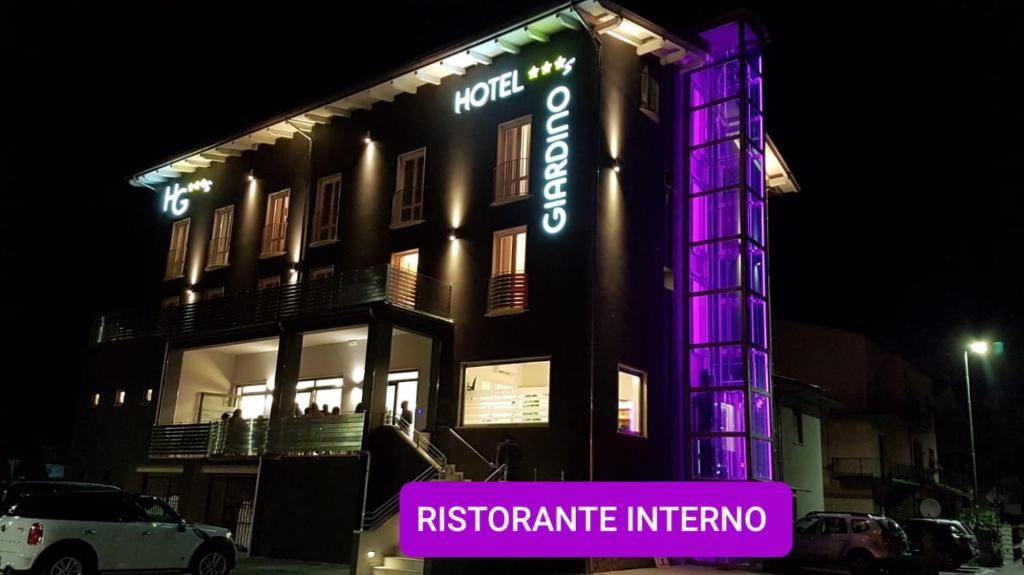 un edificio con luci viola sul lato di Hotel Giardino a Bibbiena