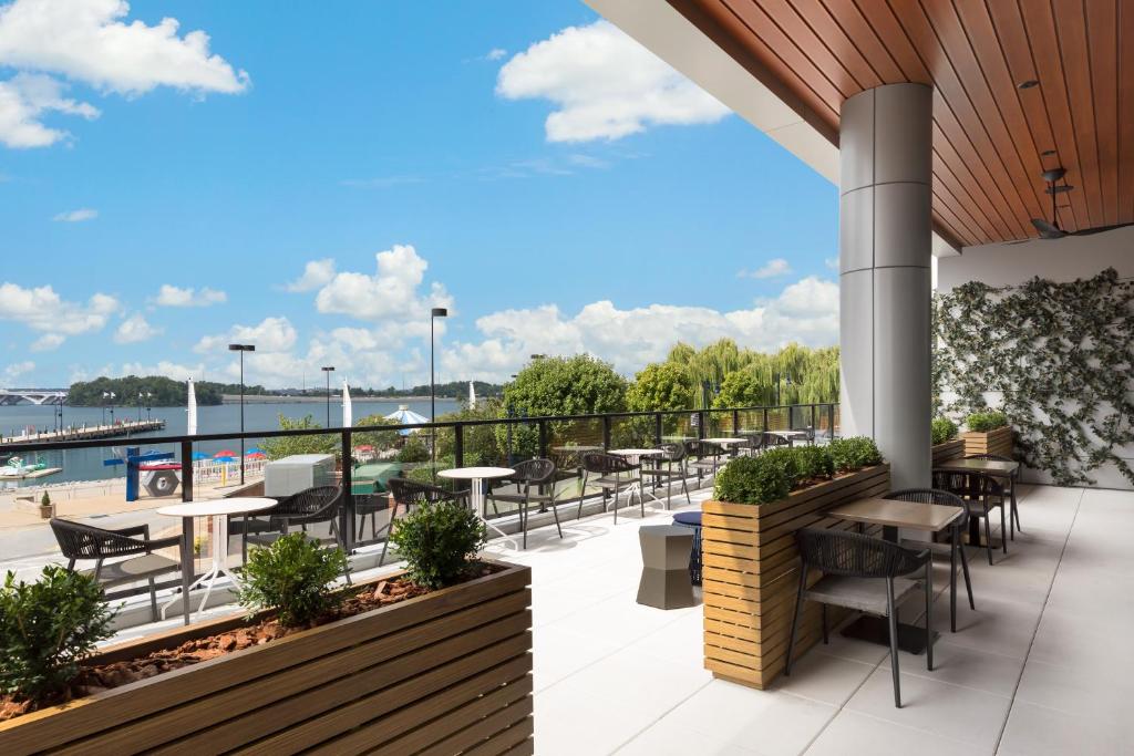 a patio with tables and chairs and a view of the water at Hyatt Place National Harbor in National Harbor