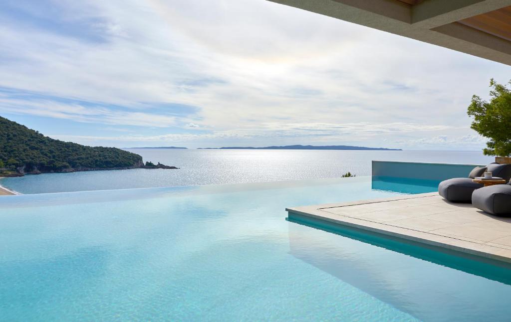 a swimming pool with a view of the water at Elix, Mar-Bella Collection in Perdika