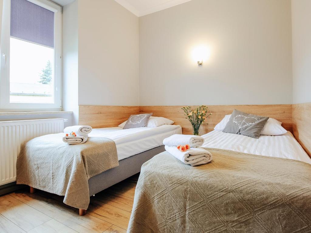 um quarto com 2 camas e toalhas em Willa Magnolia em Ciechocinek