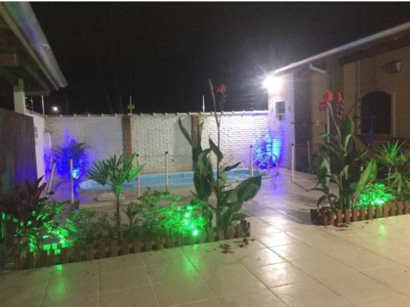 a courtyard at night with green and blue lights at Casa do Sergio in Caraguatatuba