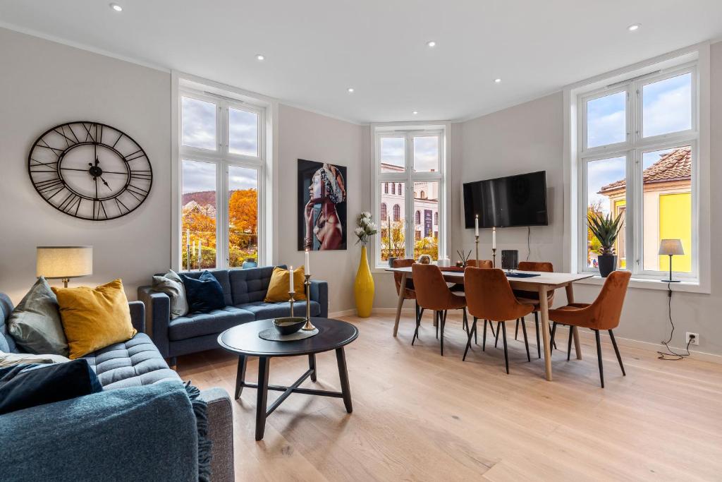 a living room with a blue couch and a dining room at Keyser Apartments 8 in Bergen