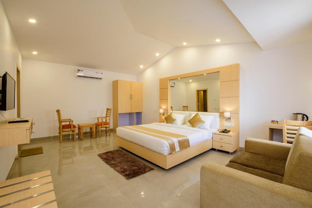 a hotel room with a bed and a living room at De Lagom Comforts, Anjuna Beach near Diaz club in Anjuna