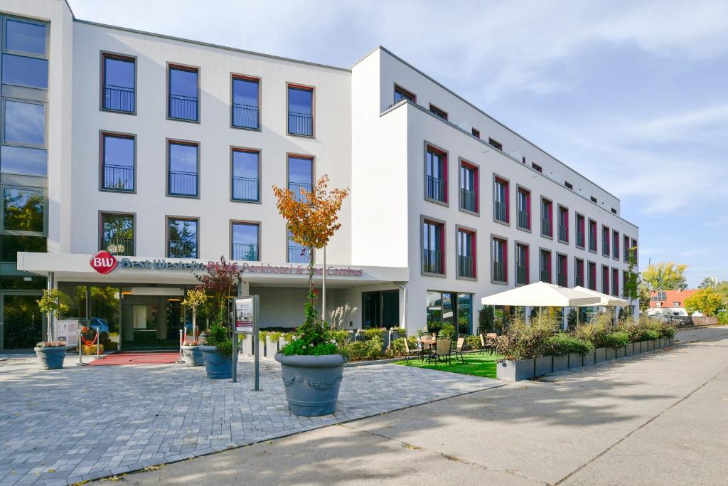 un gran edificio blanco en una calle de la ciudad en Best Western Plus Parkhotel & Spa Cottbus, en Cottbus