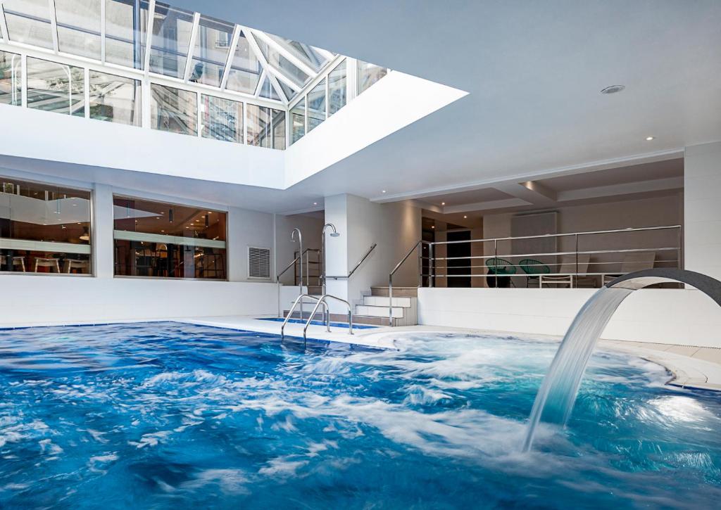 a swimming pool with a water feature in a house at Oceania Paris Porte De Versailles in Paris