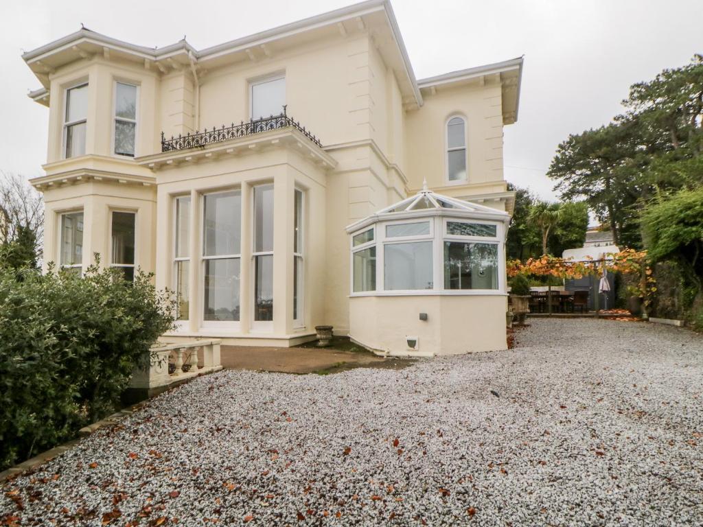 a house with a gravel driveway in front of it at Holcombe House in Torquay