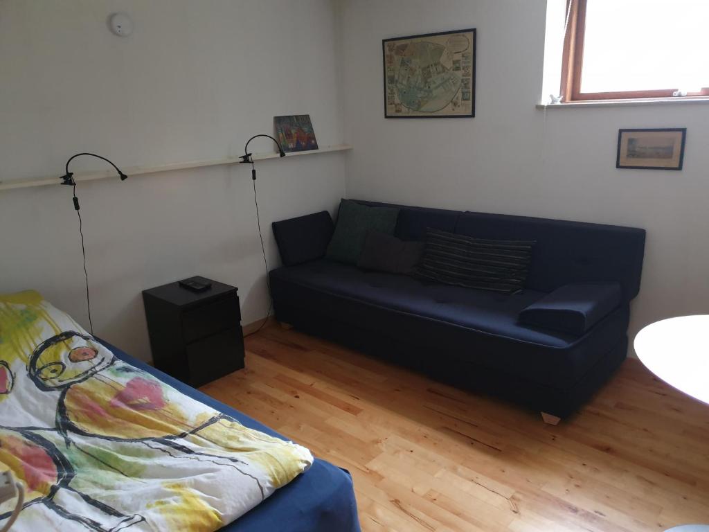 een woonkamer met een blauwe bank en een tafel bij Underetage i Dronningborgvilla in Randers
