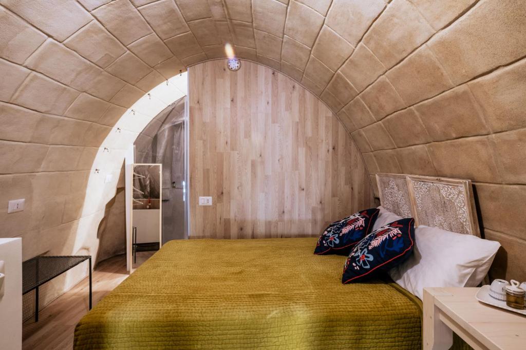 ein Schlafzimmer mit einem großen Bett in einer Steinmauer in der Unterkunft 19.52 Matera in Matera