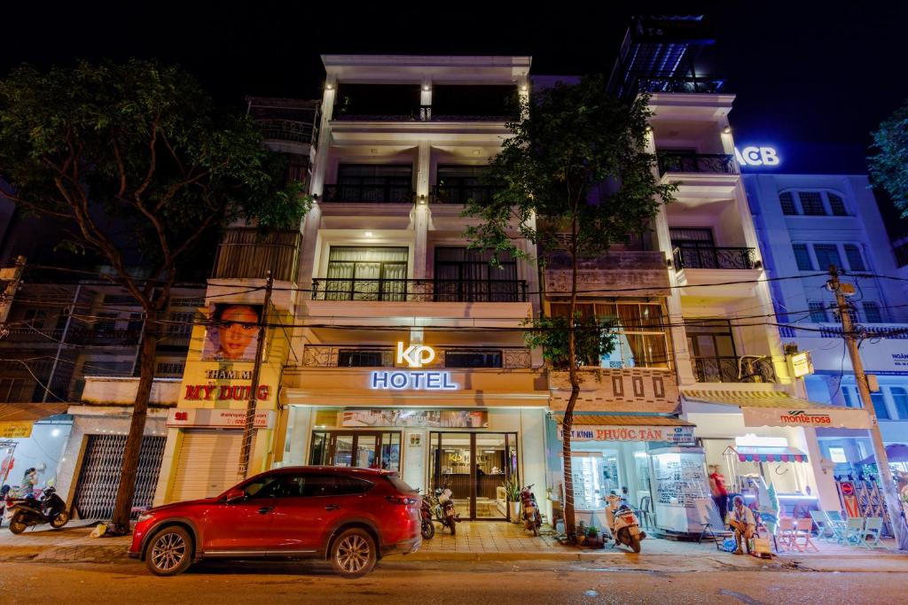a red car parked in front of a building at KP Hotel in Can Tho