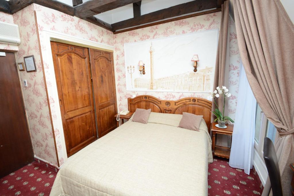 - une petite chambre avec un lit et une fenêtre dans l'établissement Familia Hotel, à Paris