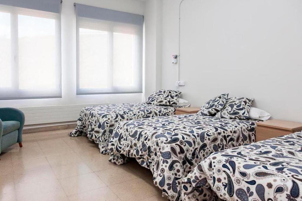 ハカにあるResidencia Albergue Jacaのベッド2台、ソファ、窓が備わる客室です。