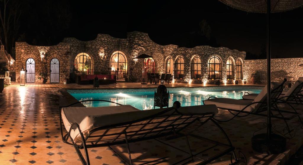 a swimming pool in a building at night at Villa Amaryllis in Ghazoua