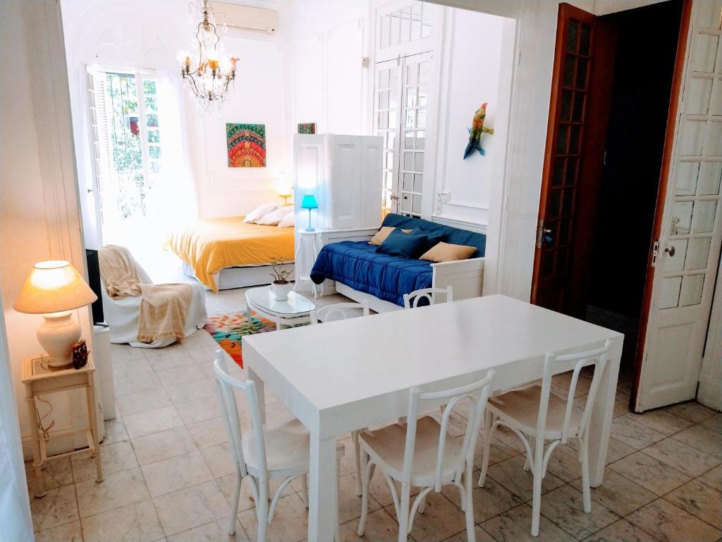 een woonkamer met een witte tafel en een bed bij Casa Palacio, Arte e Historia in Buenos Aires