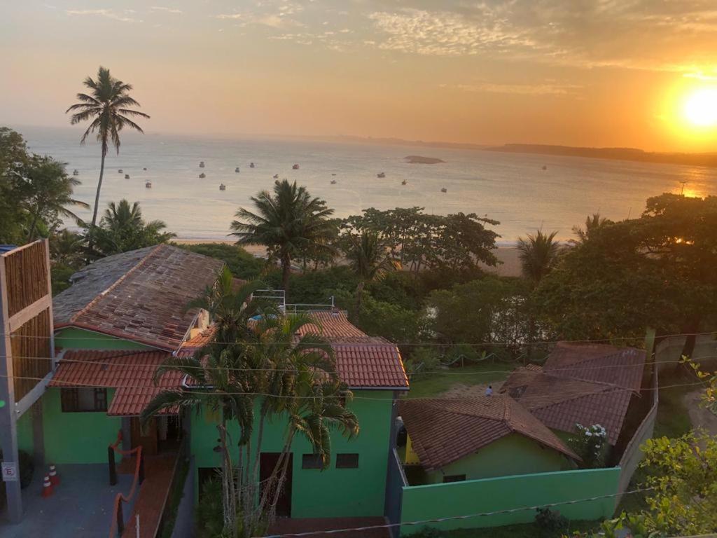 a view of the ocean from a house with the sunset at Pousada Caravelas in Guarapari