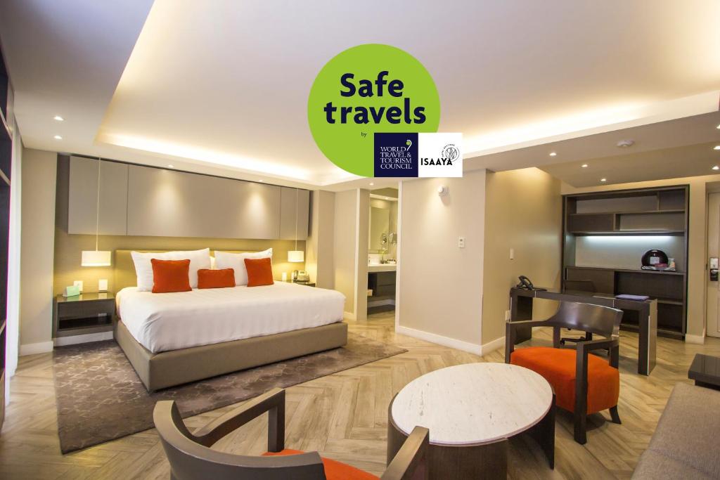 une chambre d'hôtel avec un lit et une salle à manger dans l'établissement Isaaya Hotel Boutique by WTC, à Mexico