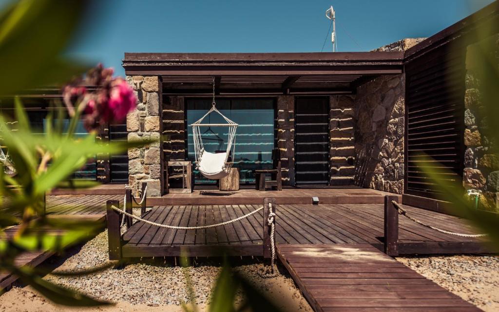 a wooden deck with a chair and a swing at Keros Blue - Luxury in Wilderness in Kalliópi