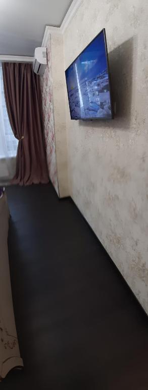 a room with a tv on a wall with a window at 36 жемчужина. Аркадия in Odesa