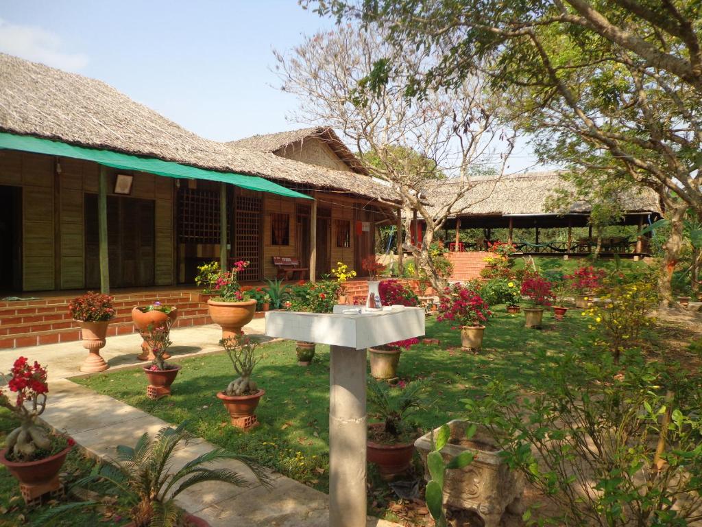 ein Haus mit einem Garten mit Topfpflanzen und einem Waschbecken in der Unterkunft Phuong Thao Homestay in Vĩnh Long