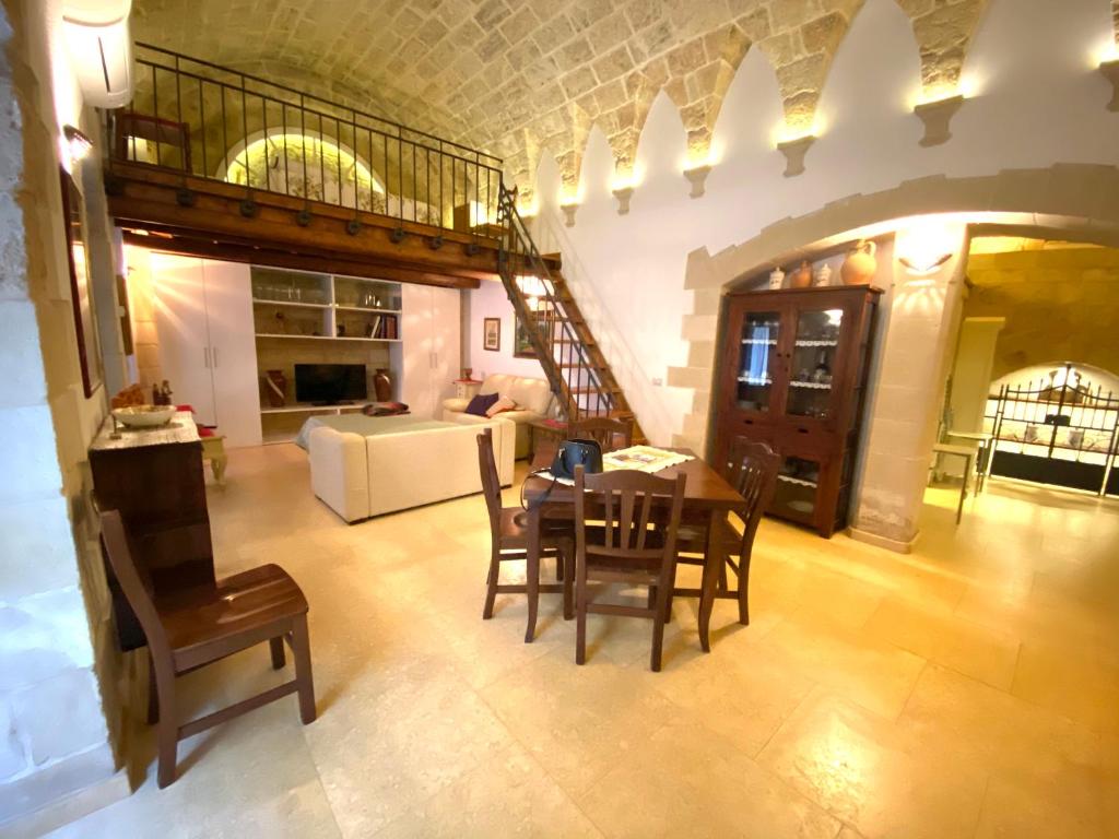 ein großes Wohnzimmer mit einem Tisch und Stühlen in der Unterkunft San Domenico Suite in Martano