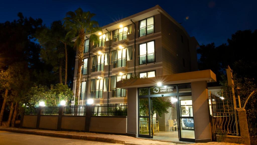 un bâtiment avec une façade de magasin la nuit dans l'établissement OPERA SUITES Apart Hotel, à Antalya