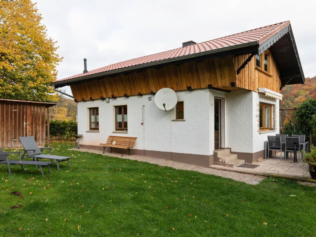 a white house with a wooden roof and a yard at Holiday home in the Thuringian Forest in Wutha-Farnroda