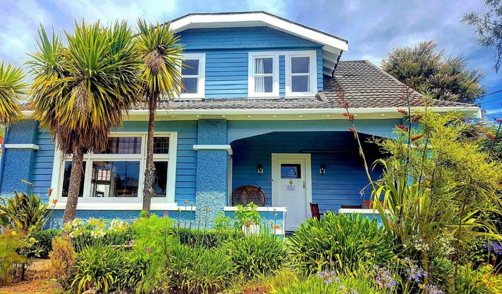 ein blaues Haus mit einer Palme davor in der Unterkunft The Gables B&B in Picton