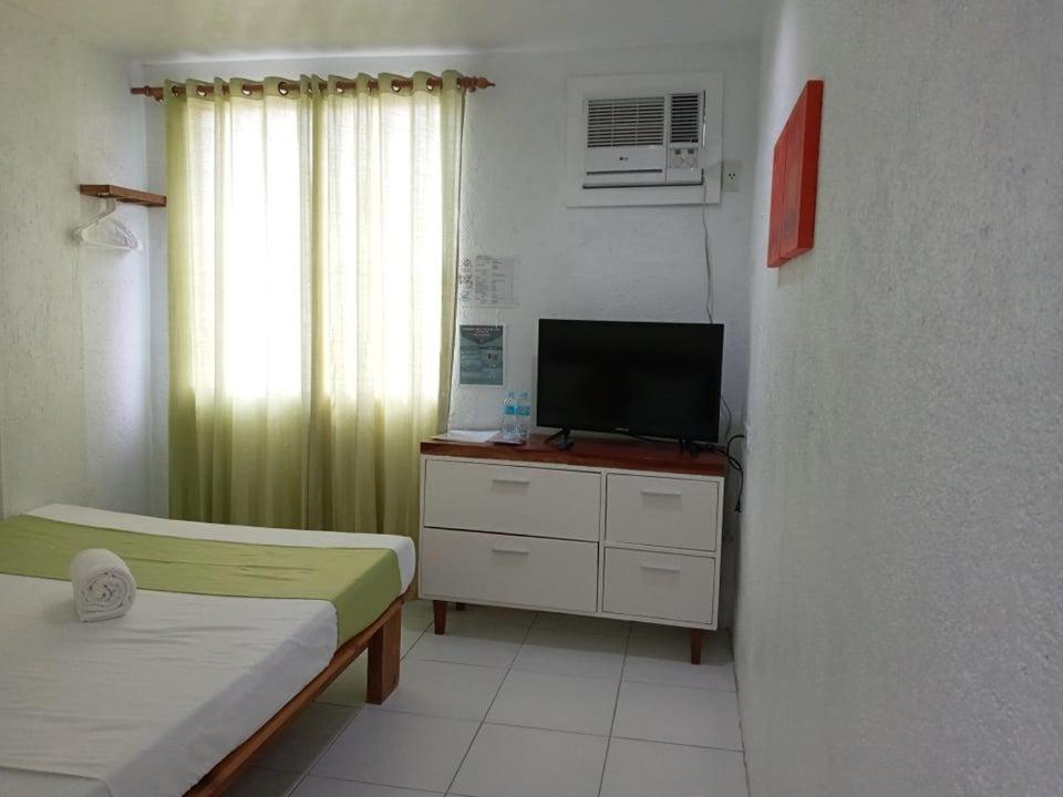 a room with two beds and a television in a room at MR Holidays Hotel in Boracay