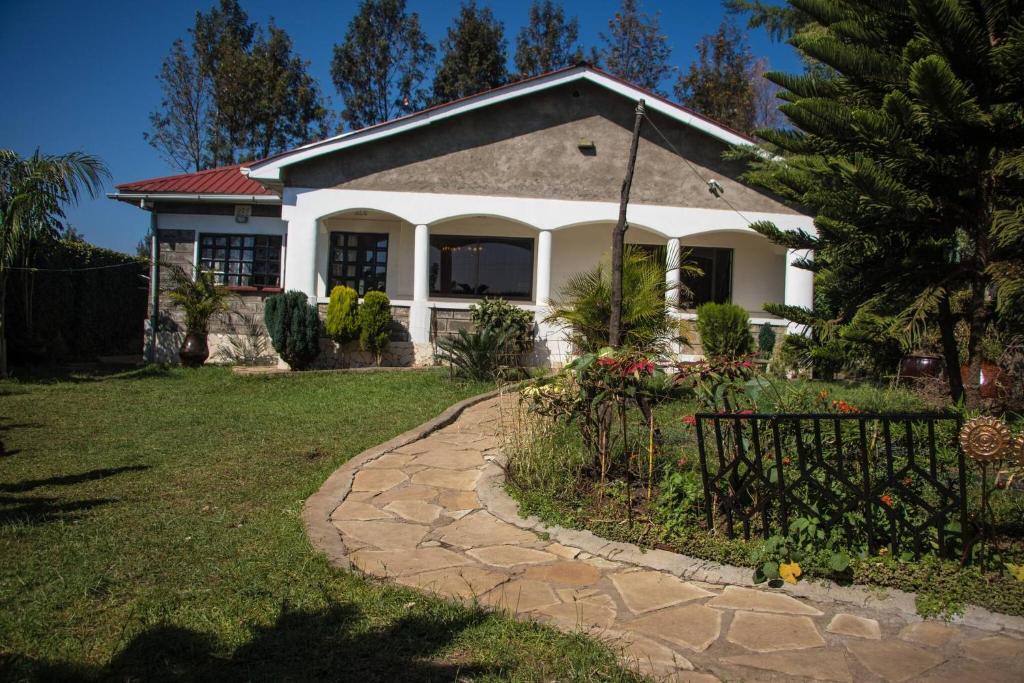 ein Haus mit einem Zaun vor einem Hof in der Unterkunft Room in Bungalow - Reens Vacation Rental Home in Nakuru