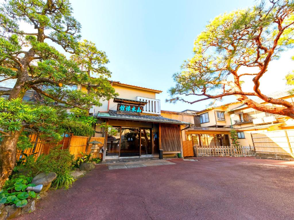 Atami Onsen Yamaki Ryokan في أتامي: منزل أمامه ممر