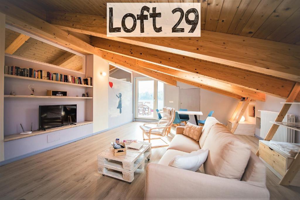 uma sala de estar com um sofá branco e um sinal de lote em Loft 29 mansardato con ampio terrazzo em Bussoleno