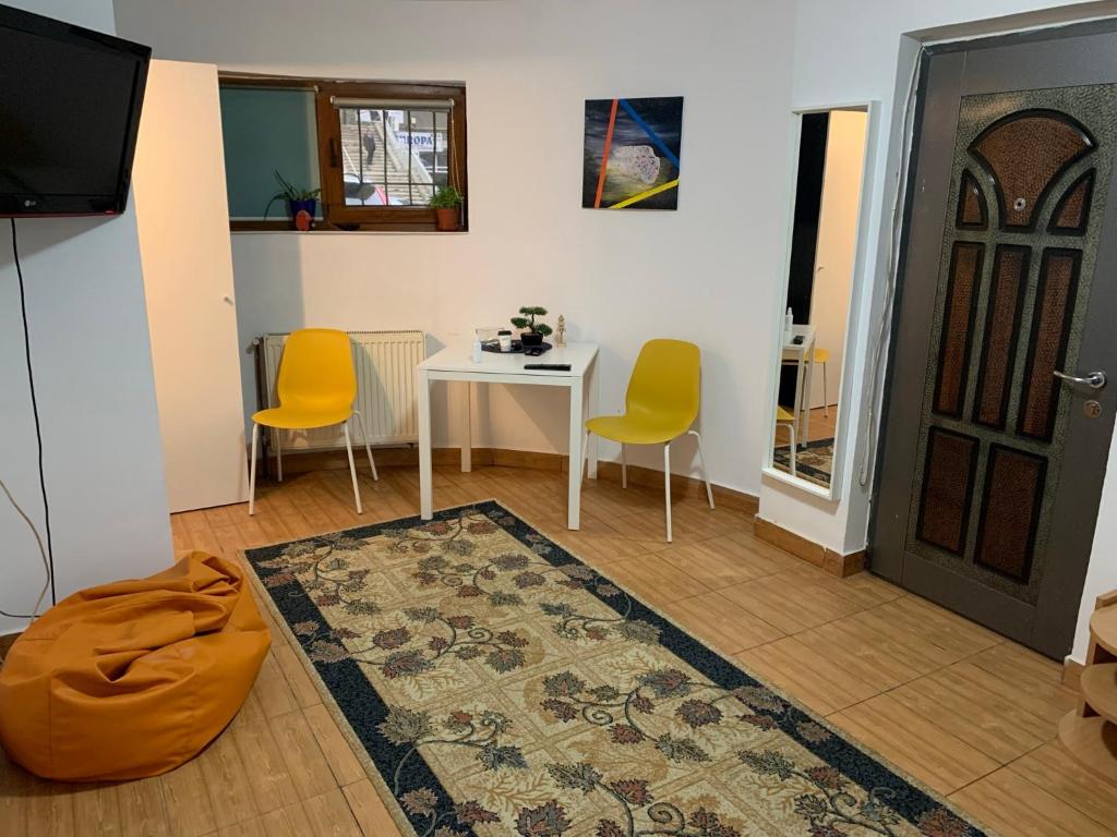 - un salon avec une table, des chaises et une porte dans l'établissement Ultracentral Lozonschi Apartament Parter, à Iaşi