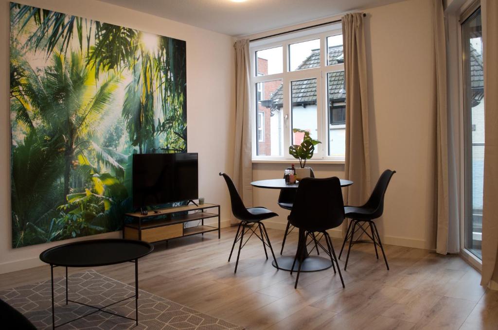 een woonkamer met een tafel en stoelen en een schilderij bij The Residence Enschede in Enschede