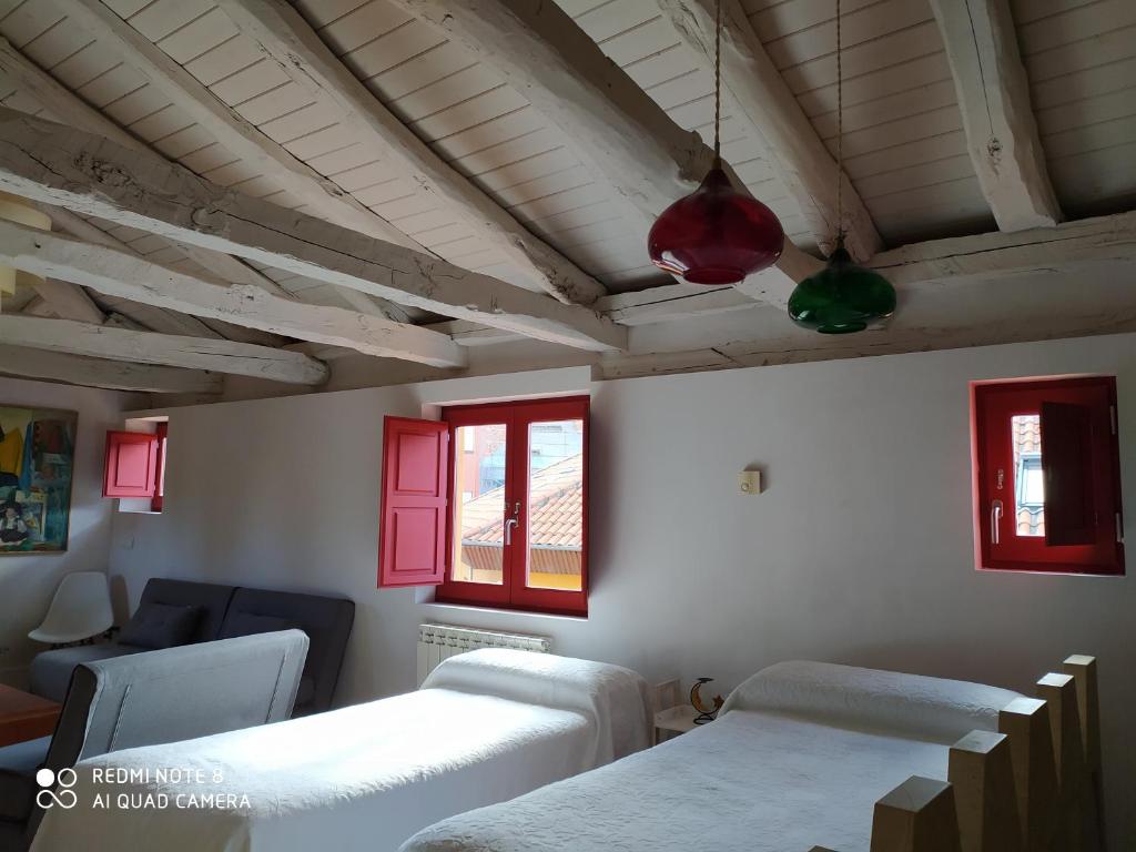 レオンにあるLa Casita de Leónの赤い窓のある病室で、ベッド2台が備わります。
