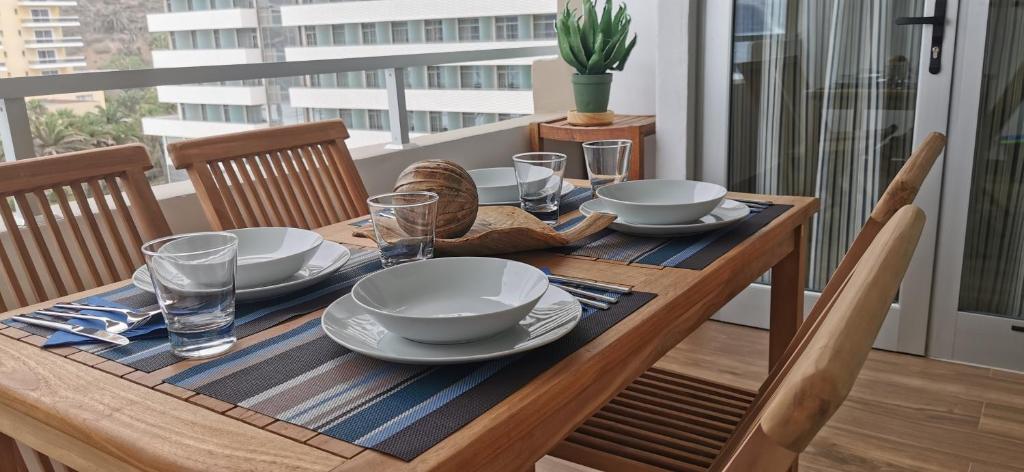 a wooden table with plates and bowls on it at LE TERRAZZE 4 in Puerto de la Cruz